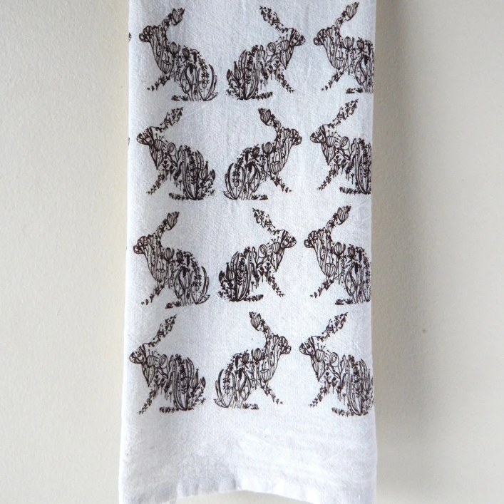 White towel with black rabbit pattern on a white background