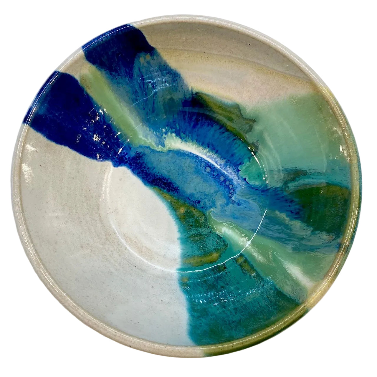 A handmade ceramic bowl with a glossy finish, featuring an abstract marbled pattern of deep blue, teal, green, and white glaze on a light beige clay base.