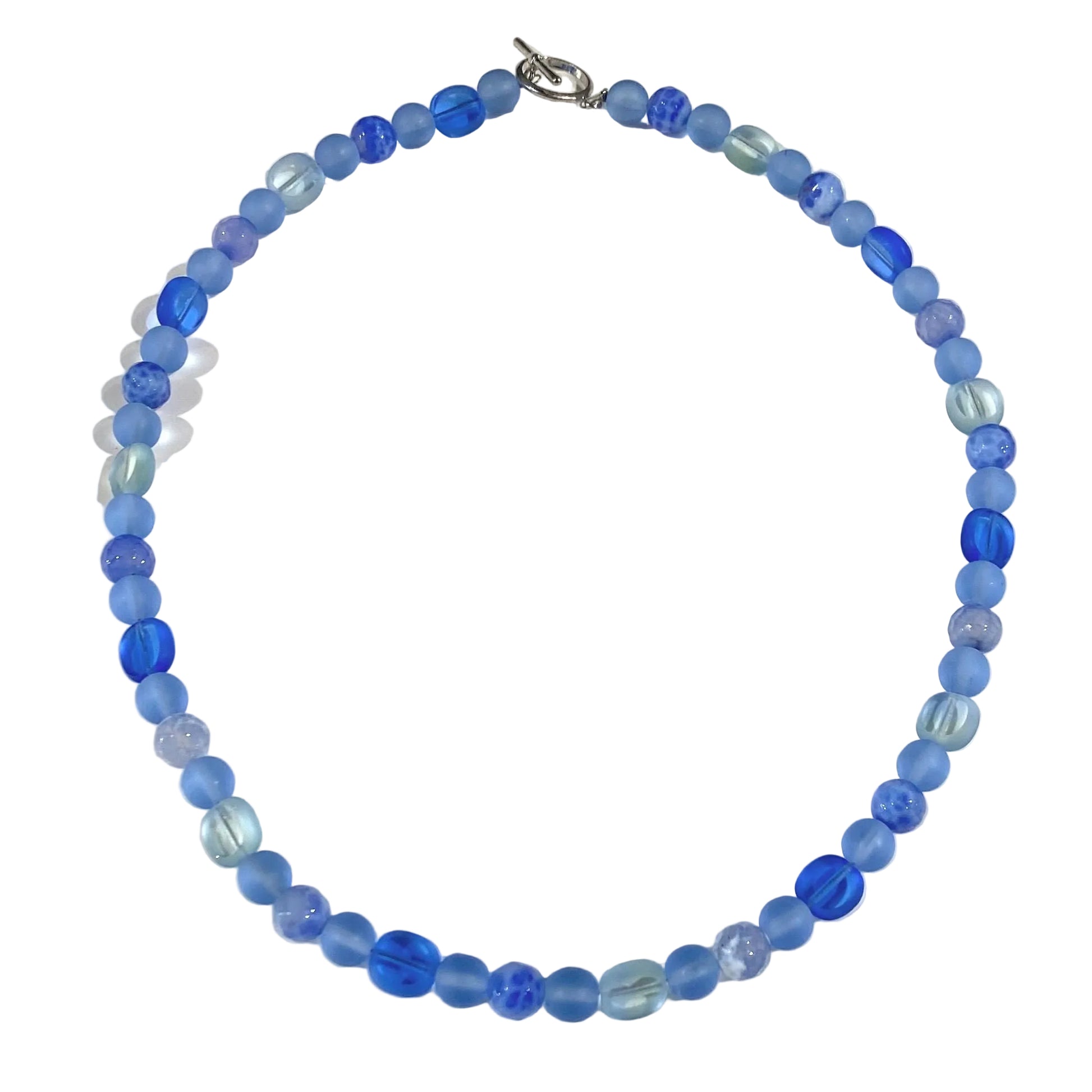 A beaded necklace made of round faceted beads in various shades of blue, from light sky blue to deep royal blue, with a silver clasp, shown on a plain white background.