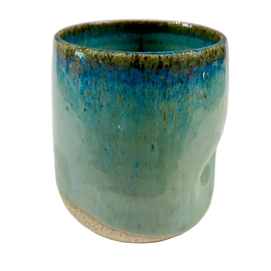 Ceramic cup with blue and green glaze on a white background