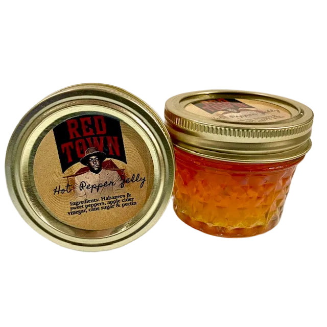 Jar of Red Town hot pepper jelly with gold lid on a white background
