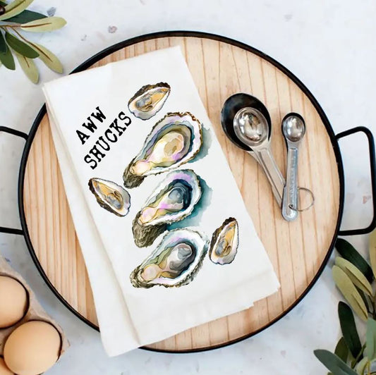A white kitchen towel with a printed oyster shell illustration and the text 'A.W.