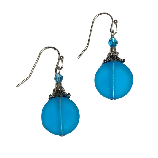 Blue round earrings with silver hooks on a light gray background