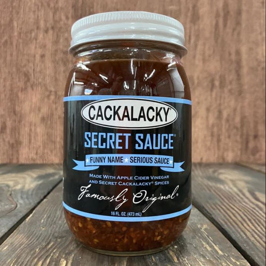Jar of Cackalacky Secret Sauce on a wooden surface