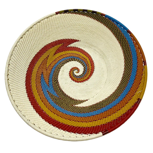 Woven basket with a spiral pattern in various colors on a white background