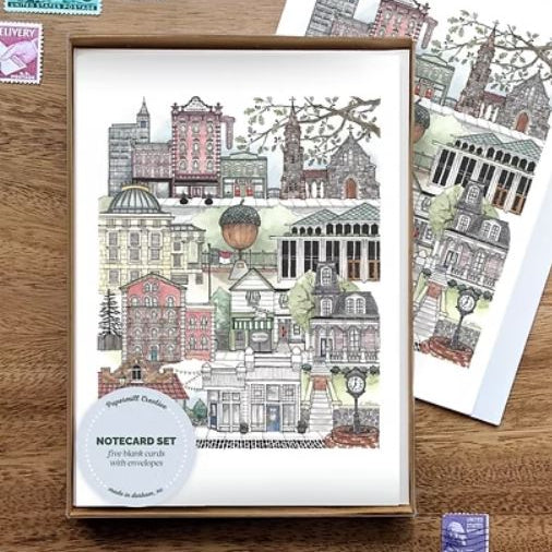 Notecard set with illustrated cityscape design on a wooden surface
