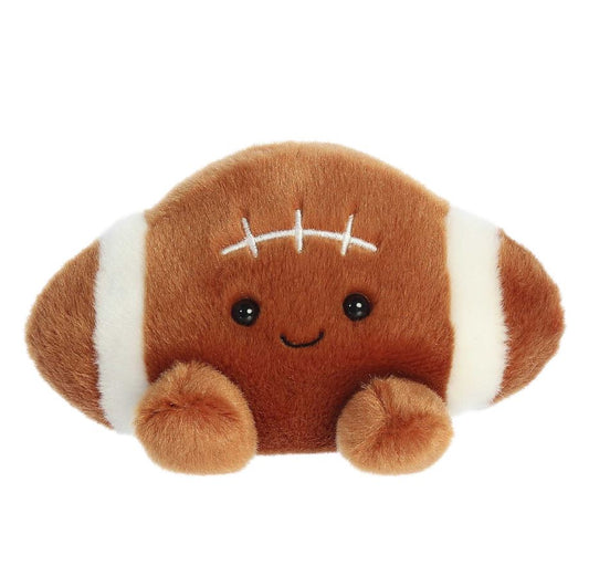 Plush toy shaped like a football with a smiling face on a white background