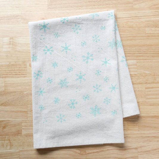 White towel with blue snowflake patterns on a wooden surface