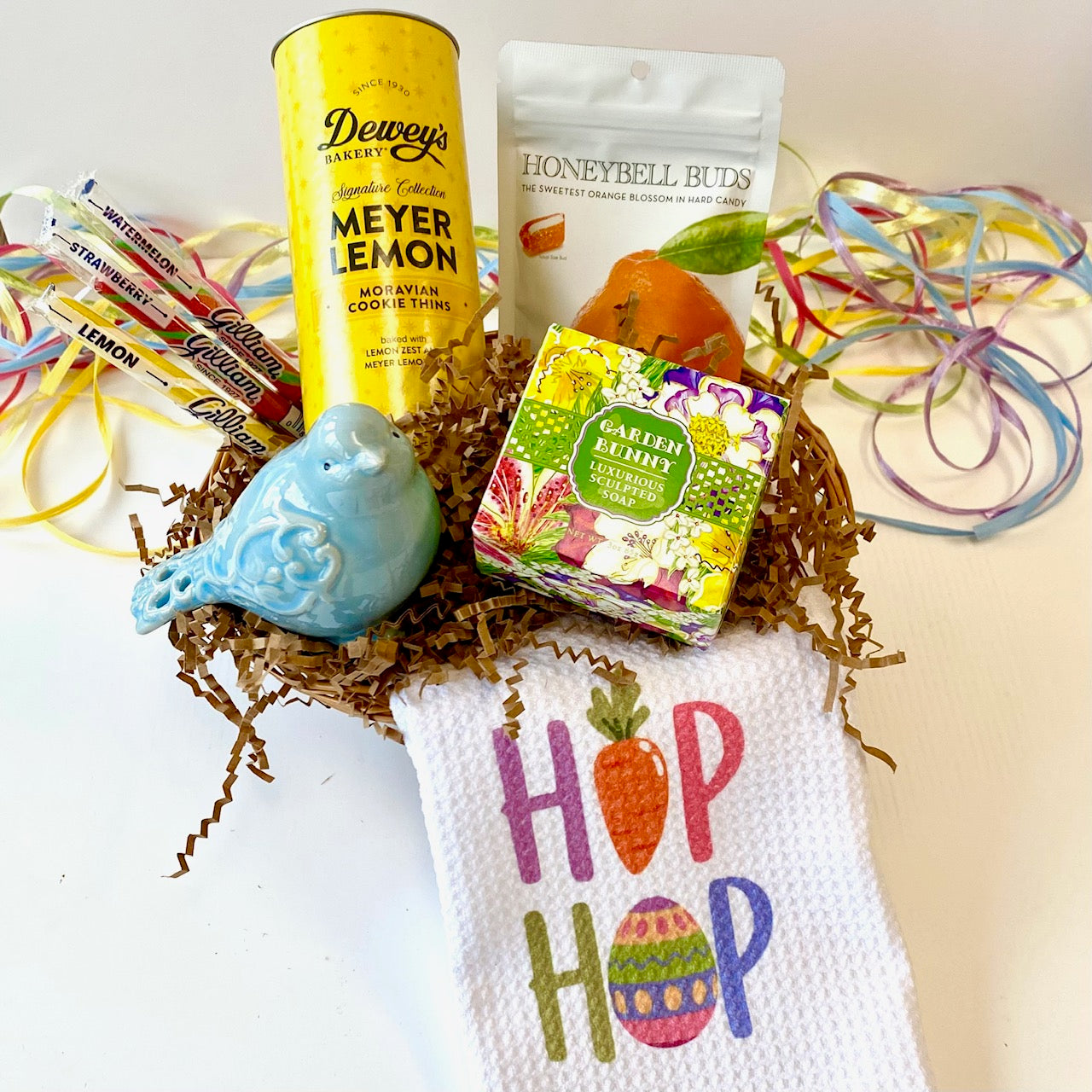 Easter-themed gift basket with lemon cookies, candy, and a towel with 'Hop Hop' text.