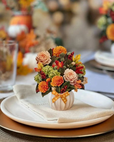 Decorative floral arrangement on a plate with a blurred festive background
