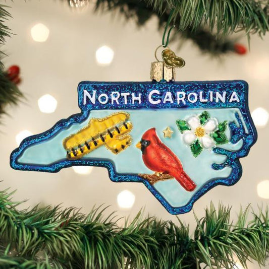 North Carolina-themed Christmas ornament with a cardinal, plane, and flower on a tree.