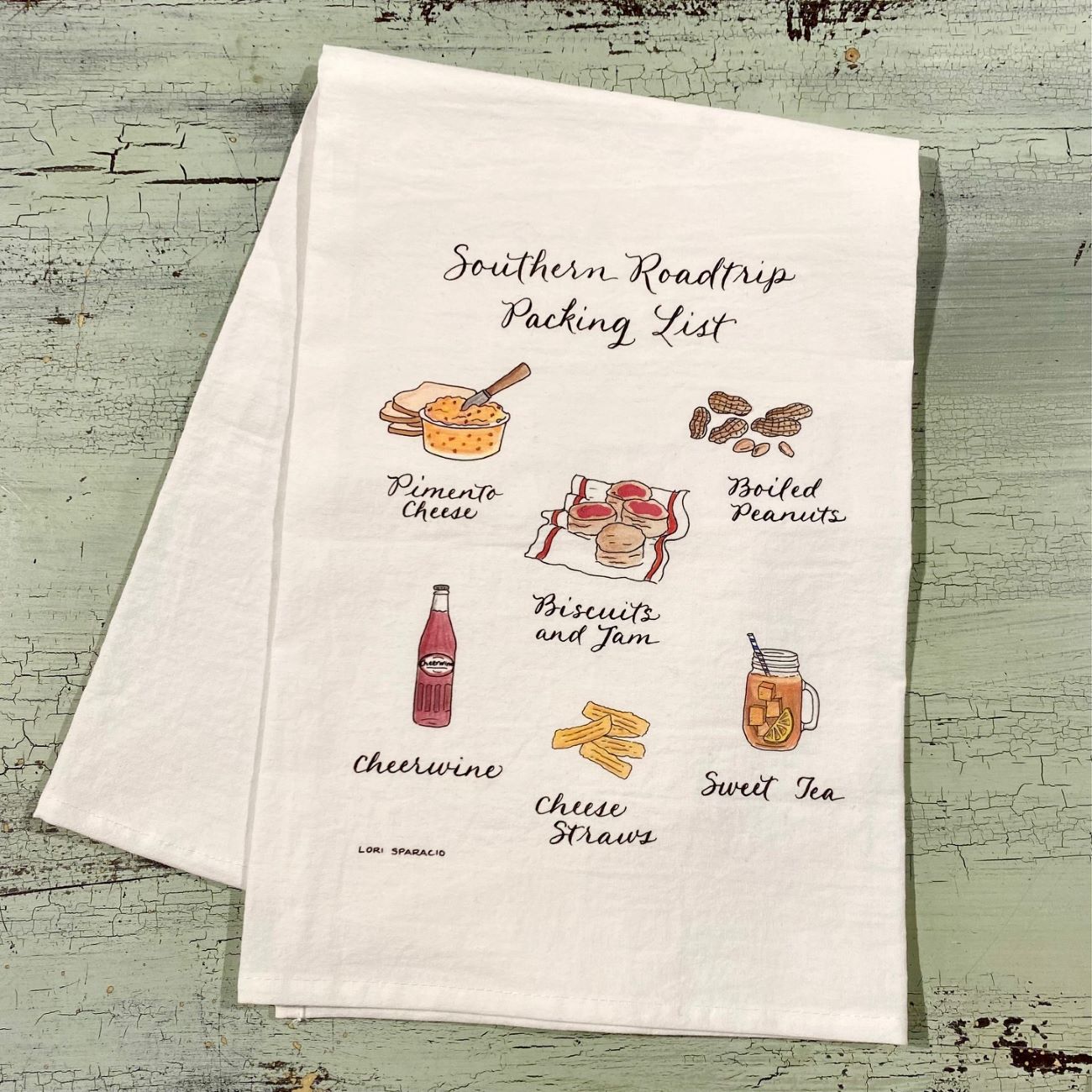 Tea towel with illustrations and text on a textured surface