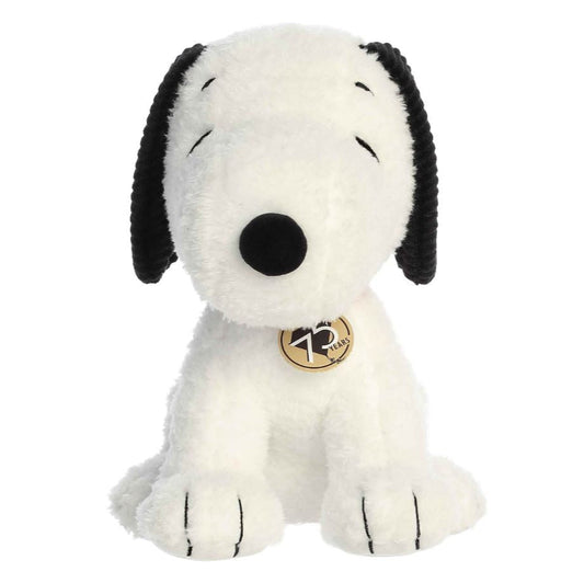 Plush dog toy with black and white fur and a gold tag on a white background
