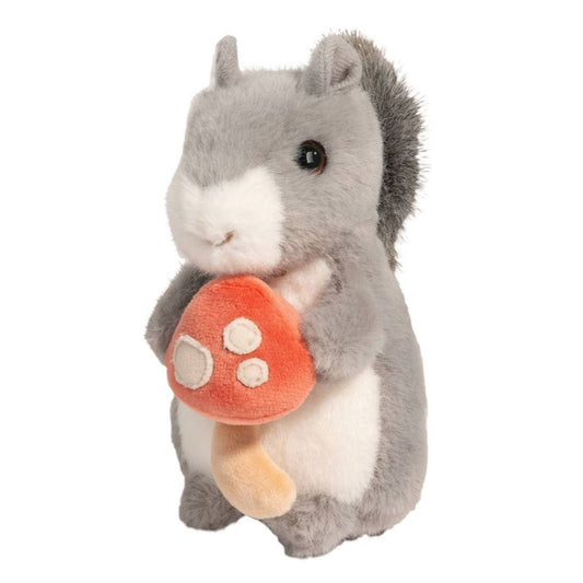 Plush toy squirrel holding a red mushroom on a white background